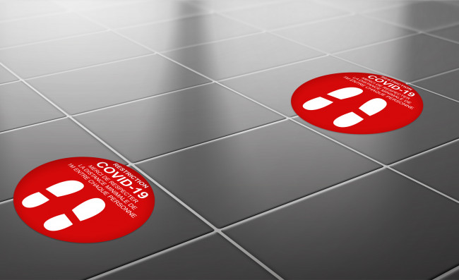 Autocollants pour la prévention et la lutte contre le coronavirus COVID-19 en vente chez Promociel Autocollant de distance COVID-19 rouge pour sol en situation dans hall d'accueil en vente chez Promociel