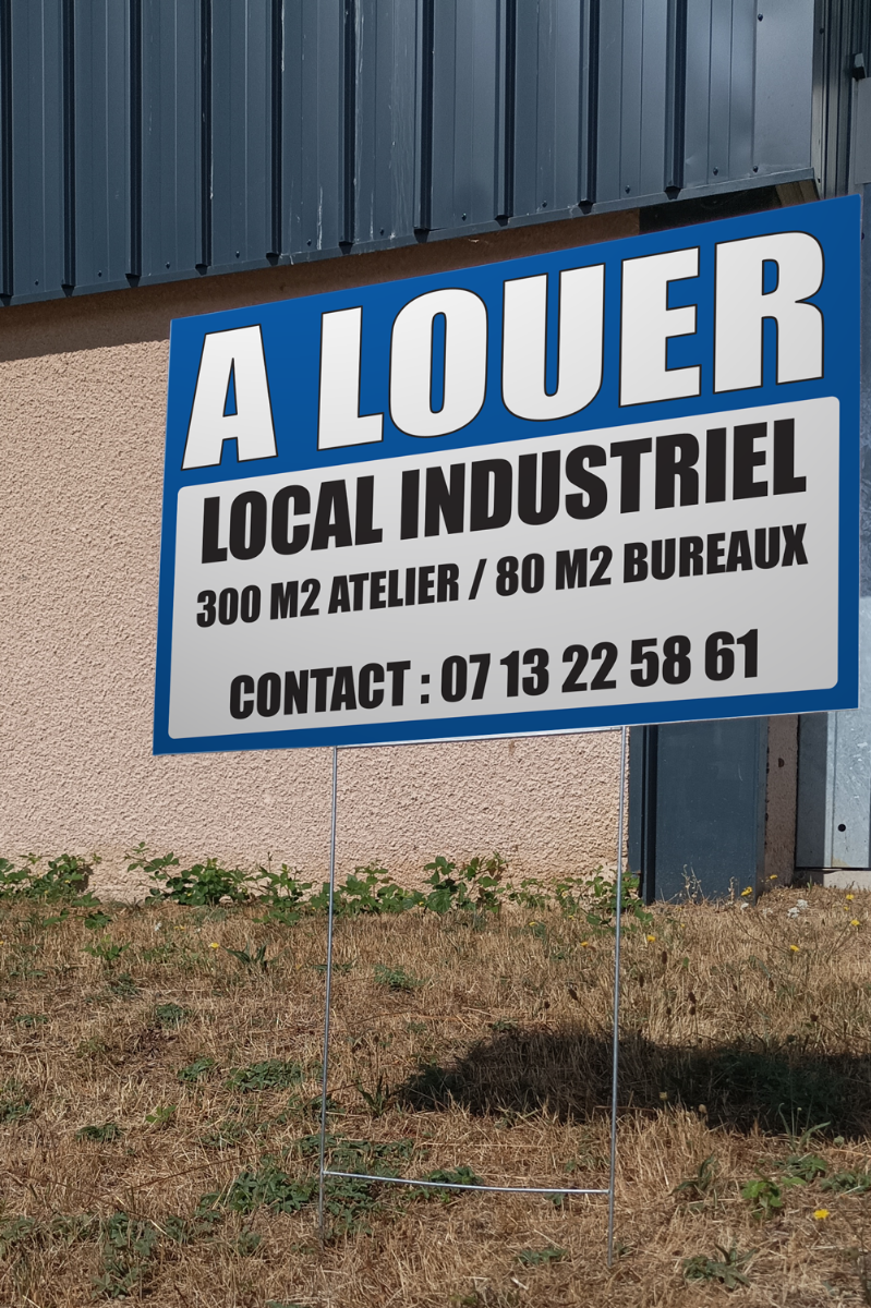 Panneau à louer 40 x 60 cm planté devant bâtiment