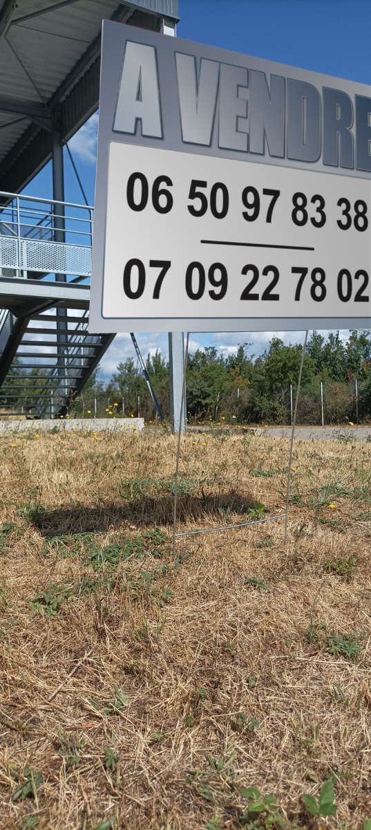 Panneau à vendre planté dans l'herbe