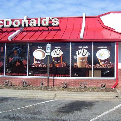 Enseigne restauration rapide vitrine equipee film microperfore campagne promotionnelle visible rue