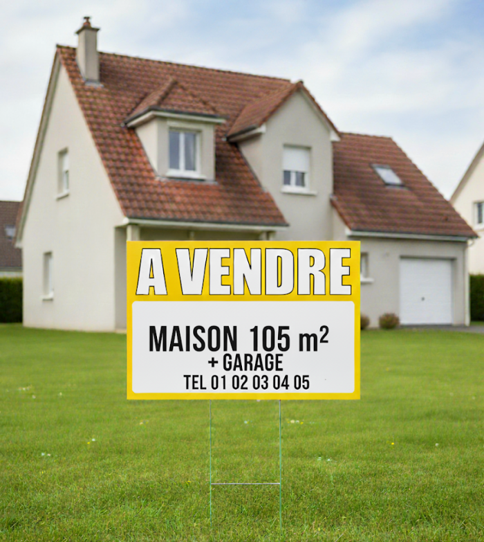 Panneau à vendre planté dans gazon devant maison